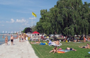 Sorra lopta el a strandolók értékeit egy fiatal férfi Siófokon
