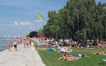Sorra lopta el a strandolók értékeit egy fiatal férfi Siófokon