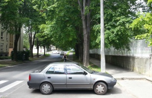 Bringaút parkoló akadállyal és vállat vonó sofőrrel