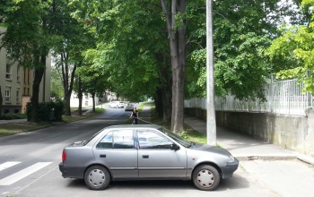 Bringaút parkoló akadállyal és vállat vonó sofőrrel